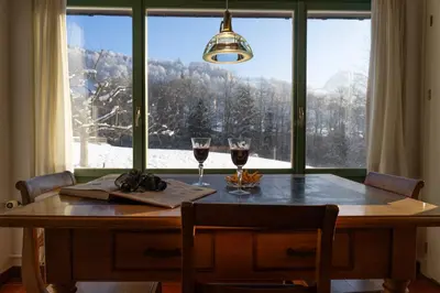 a table with two glasses of wine sitting in front of a window at Chammern in Nesslau