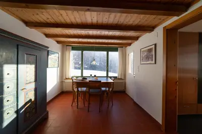 a dining room with a table and chairs and a window at Chammern in Nesslau
