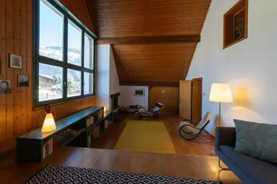 a living room with a couch and a large window at Chammern in Nesslau