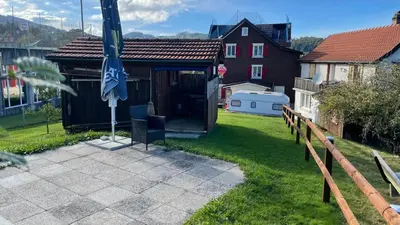 a house with an umbrella in a yard at Ferienwohnung Edelweiss in Wolfhalden