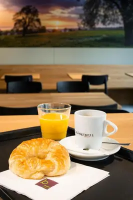 a table with a pastry and a cup of orange juice at b_smart motel Amriswil in Amriswil