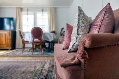 a living room with a brown couch with pillows at Blattenheimat6 - im traditionellen Appenzeller Haus in Appenzell