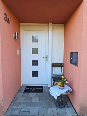 a door with a table and a chair in front of it at Private Etage 5 Min vom Bahnhof - Parken - Küche - Netflix in Widnau