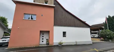 a red and white house with a black roof at Private Etage 5 Min vom Bahnhof - Parken - Küche - Netflix in Widnau
