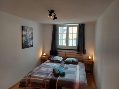 a bedroom with a bed with two pillows and a window at Global Citizen 5 in St. Gallen