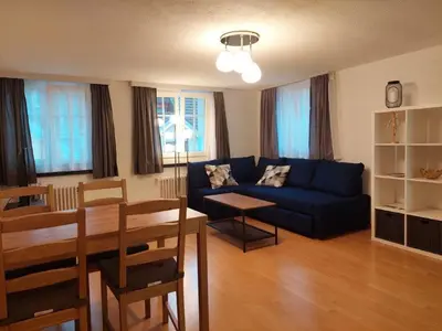 a living room with a blue couch and a table at Global Citizen 7 in St. Gallen