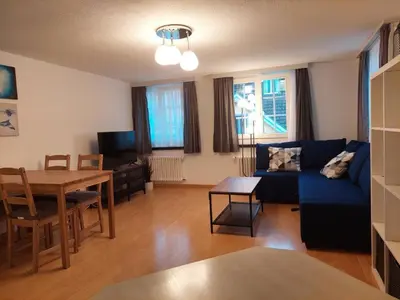 a living room with a blue couch and a table at Global Citizen 7 in St. Gallen