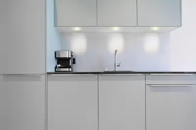 a kitchen with white cabinets and a sink at VISIONAPARTMENTS St Gallen - contactless check-in in St. Gallen