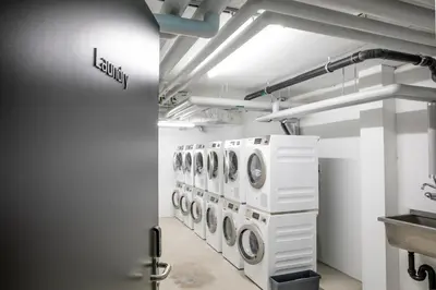 a laundry room with a row of washers and dryers at VISIONAPARTMENTS St Gallen - contactless check-in in St. Gallen