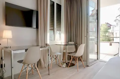 a hotel room with a table and chairs and a bed at VISIONAPARTMENTS St Gallen - contactless check-in in St. Gallen