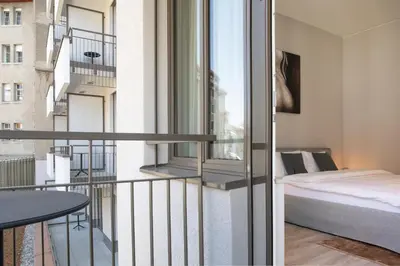 a bedroom with a bed and a balcony with a window at VISIONAPARTMENTS St Gallen - contactless check-in in St. Gallen