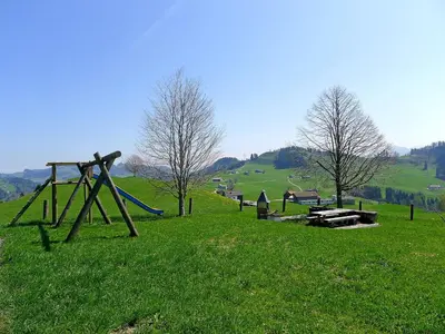 a stone stove in a field with mountains in the background at Apartment Panoramablick by Interhome in Haslen