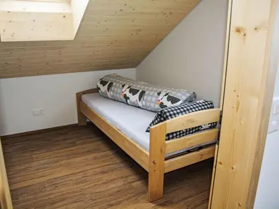 a small room with a bed in the attic at Apartment Panoramablick by Interhome in Haslen