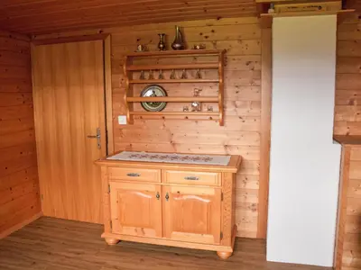 a kitchen with a stove in a wooden cabin at Apartment Panoramablick by Interhome in Haslen