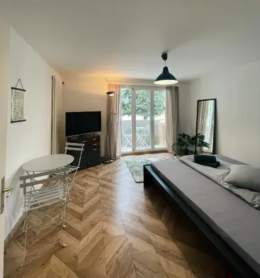 a bedroom with a bed and a table and a television at Gemütliches Studio nahe Bodensee in Arbon