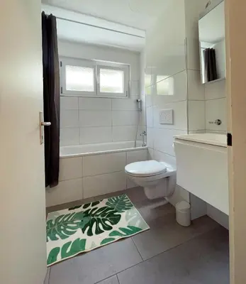 a bathroom with a toilet and a tub and a sink at Gemütliches Studio nahe Bodensee in Arbon