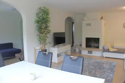 a living room with two blue chairs and a fireplace at Rietidylle mit atemberaubendem Blick auf die Churfirsten in Wildhaus