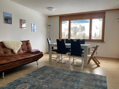a living room with a couch and a table and chairs at Rietidylle mit atemberaubendem Blick auf die Churfirsten in Wildhaus