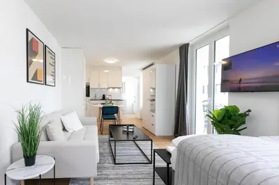 a white living room with a couch and a table at INN JOY Apartments - Roter Platz in St. Gallen