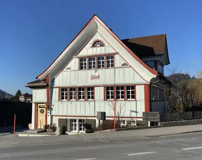 a large white and red building on the side of a street at Ferienwohnung Bärli Appenzell in Appenzell
