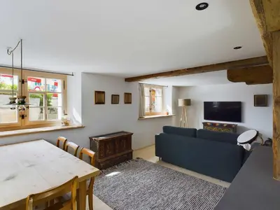 a living room with a blue couch and a table at Ferienwohnung Bärli Appenzell in Appenzell