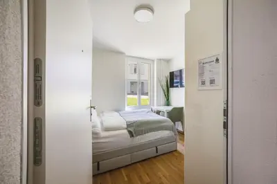 a bedroom with a bed in a room with a window at HRE Apartments St Gallen City Center in St. Gallen