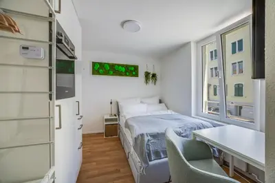 a bedroom with a bed and a table and chairs at HRE Apartments St Gallen City Center in St. Gallen