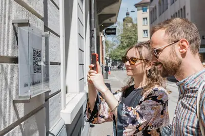 a man and a woman looking at a cell phone at Klara 1022 - Olma, Spital, Uni St- Gallen in St. Gallen