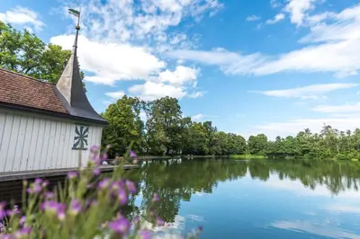 a church sitting next to a river with flowers at Klara 1022 - Olma, Spital, Uni St- Gallen in St. Gallen