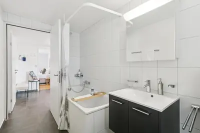 a white bathroom with a sink and a tub at Klara 1022 - Olma, Spital, Uni St- Gallen in St. Gallen
