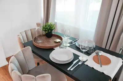 a dining room table with plates and wine glasses at Book2Stay - modernes Studio OLMA-Areal in St. Gallen