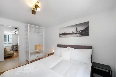 a bedroom with a bed with a white bedspread at book2stay modernes Apartment OLMA-Areal in St. Gallen