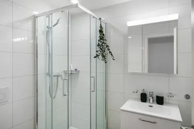 a bathroom with a glass shower and a sink at book2stay modernes Apartment OLMA-Areal in St. Gallen