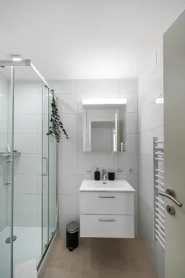 a white bathroom with a sink and a shower at book2stay modernes Apartment OLMA-Areal in St. Gallen