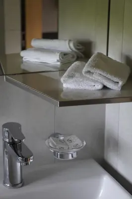 a bathroom with a sink and a mirror and towels at Hotel Kaubad in Appenzell