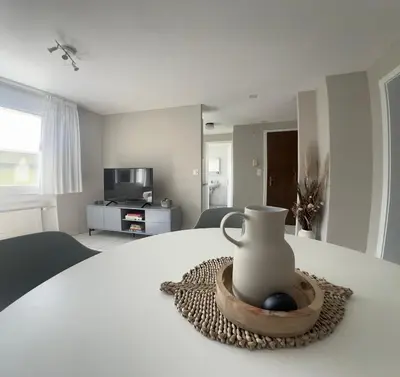 a white vase sitting on a table in a bedroom at Ferienwohnung SUN SAND SEA in Horn