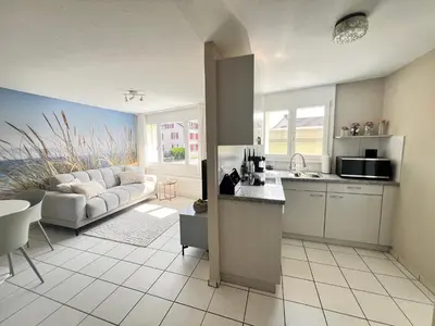 a kitchen and a living room with a couch at Ferienwohnung SUN SAND SEA in Horn