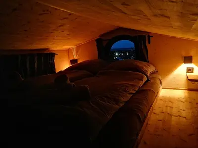 a bed in a dark room with a window at Tiny House im Grünen in Sankt Margrethen