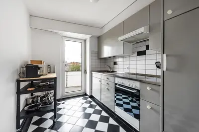 a kitchen with a black and white checkered floor at SOHO 4A !Gratis Parken, Free Parking! in Kreuzlingen