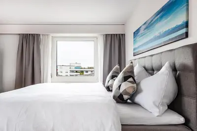 a bedroom with a large white bed with a window at SOHO 4A !Gratis Parken, Free Parking! in Kreuzlingen