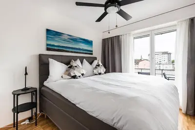 a bedroom with a bed with a ceiling fan and a window at SOHO 4A !Gratis Parken, Free Parking! in Kreuzlingen