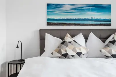 a bedroom with a bed with white sheets and pillows at SOHO 4A !Gratis Parken, Free Parking! in Kreuzlingen