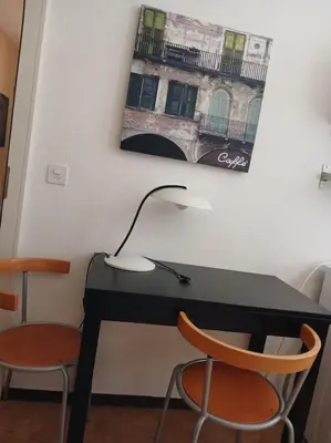 a black desk with a lamp and two chairs at Charmante Jugendstilwohnung mit Tiefengaragenplatz in St. Gallen