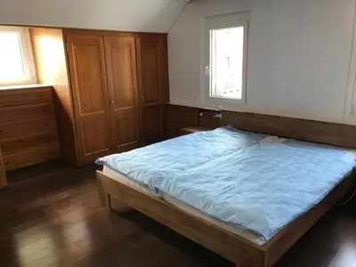 a bedroom with a large bed with a blue blanket at Ferienwohnung zentrale ruhige Lage auch gerne mit Kindern in Arbon