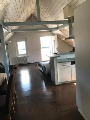 an empty room with a kitchen and a table at Ferienwohnung zentrale ruhige Lage auch gerne mit Kindern in Arbon
