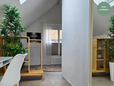 a living room with plants and a white chair at Ferienhausträume - Dachgeschoss Bodensee Apartment mit großer Dachterrasse in Kreuzlingen