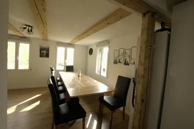 a dining room with a wooden table and black chairs at Chalet Wahida- Wellness Oase im Neckertal! in Sankt Peterzell