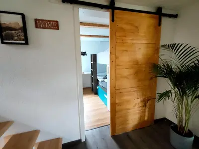 a door leading into a room with a bedroom at Chalet Wahida- Wellness Oase im Neckertal! in Sankt Peterzell