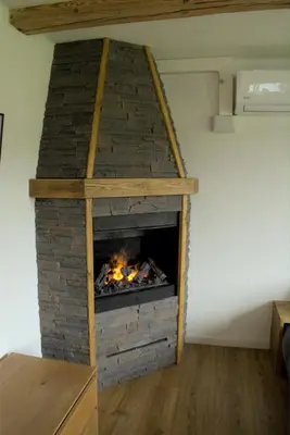 a brick fireplace in a room with a fire place at Chalet Wahida- Wellness Oase im Neckertal! in Sankt Peterzell
