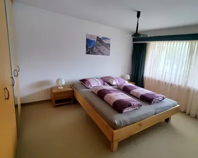 a bedroom with a bed with purple pillows on it at Ferienwohnung Halden in Unterwasser